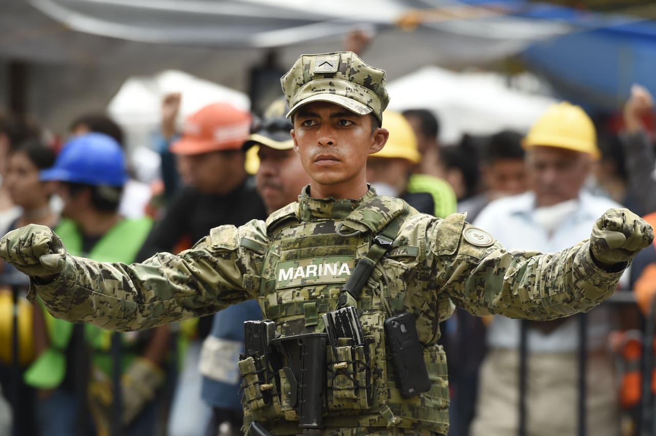 Un soldado extiende el mensaje silencio, cerca de uno de los edificios colapsado en la capital.