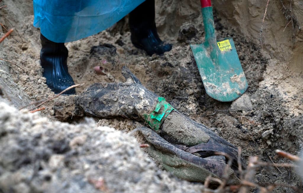 Esta imagen muestra parte del cuerpo de un soldado ucraniano que emerge del suelo durante una exhumación.