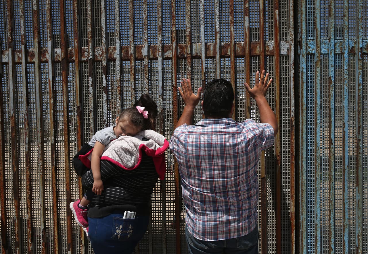 A family greet relatives on the other side of the Tijuana border.