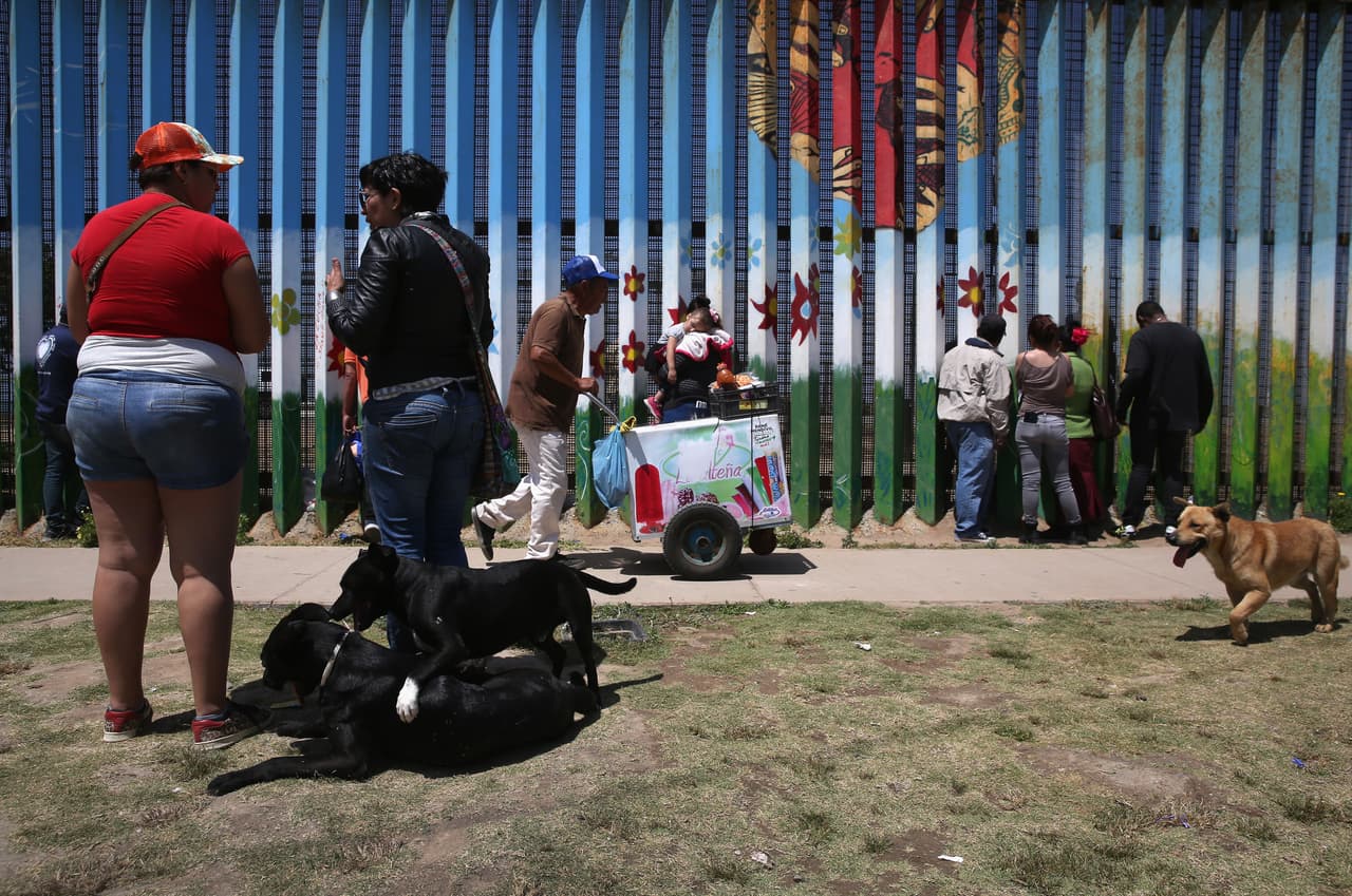 People gather on the Mexican side of the border to speak to relatives through the fence separating Tijuana and San Diego.