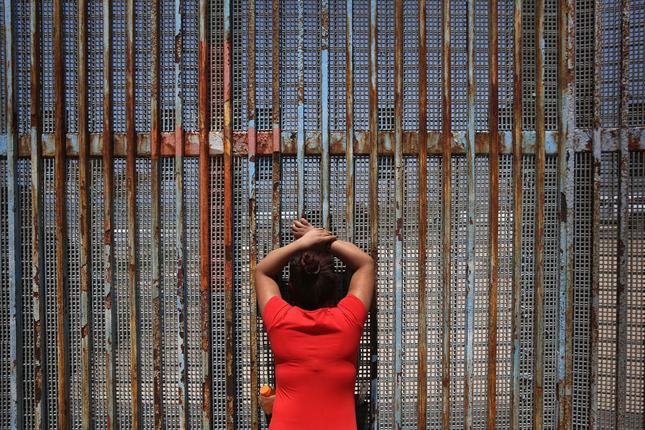 A woman meets a relative through the fence