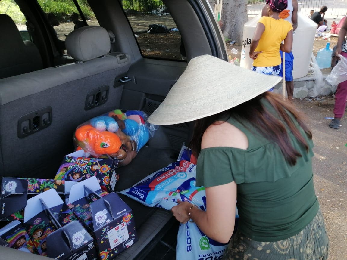 Athie recoge insumos básicos del maletero de su coche.