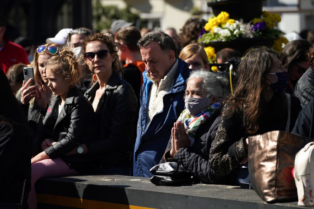 Otras personas rezan o presentan sus respetos durante los dos minutos de silencio.