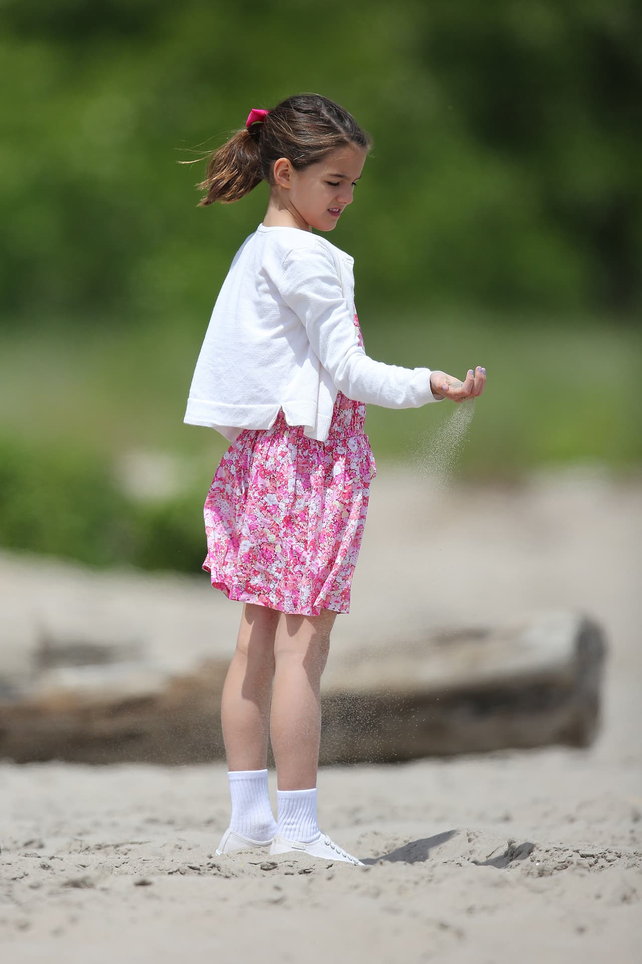 Mientras su madre, Katie, graba sus películas, Suri aprovecha para jugar hasta con arena.