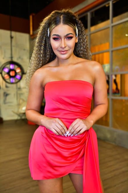 El mini vestido strapless rosado llevó la atención a su rostro y a su alborotado cabello con ondas.