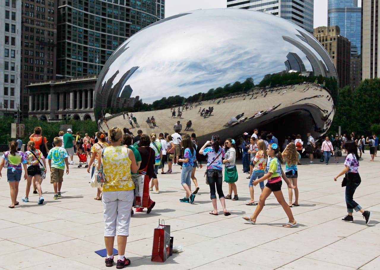 Visitantes de muchas partes de la ciudad van a Millennium Park a disfrutar de la escultura icónica "Cloud Gate", también conocida como "The Bean" en Chicago.