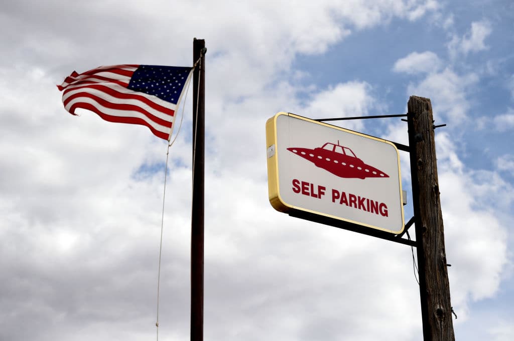 En el restaurante y tienda de souvenirs Little A'le'Inn se ve una señal de estacionamiento para platillos voladores desde el 22 de julio de 2019 en Rachel, Nevada. Una de las teorías de conspiración es que el gobierno está realizando pruebas secretas con extraterrestres en la zona.