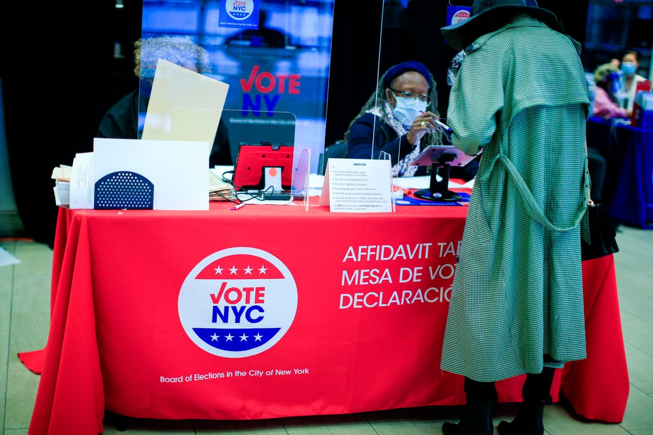 Un trabajador electoral ayuda a los votantes tempranos a votar para las elecciones presidenciales de 2020 en el Madison Square Garden,