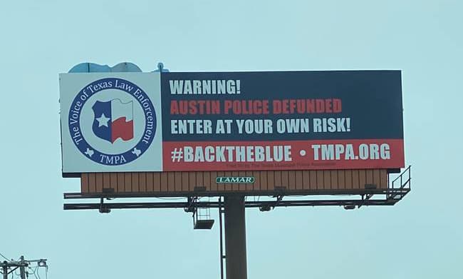 “Entre bajo su propio riesgo": Lo que dice una valla publicitaria contra los recortes de fondos de la policía