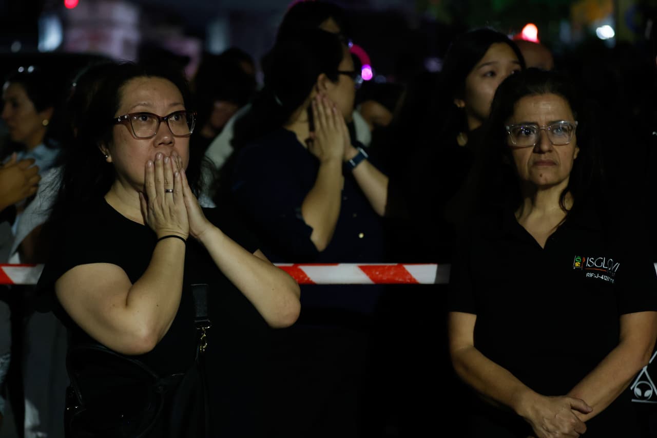 Mujeres observan un edificio derrumbado tras el siniestro natural.