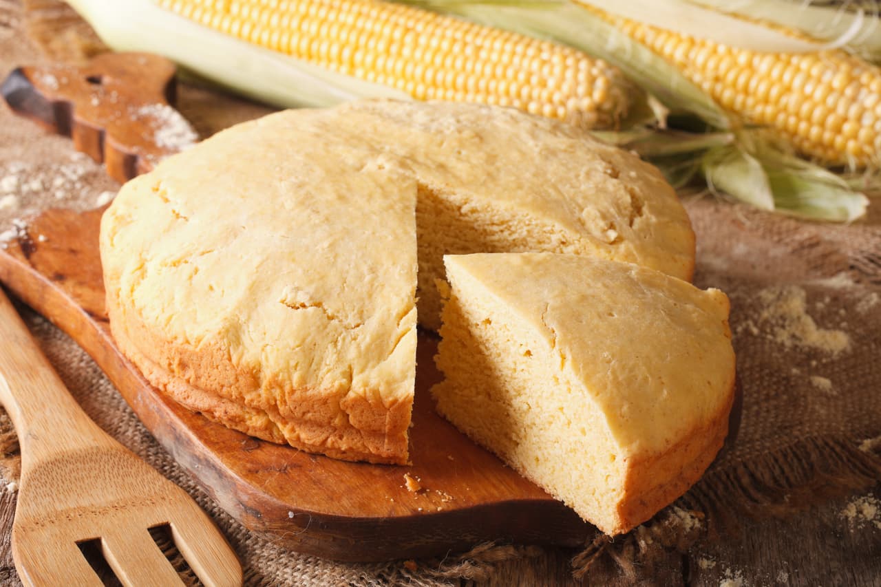 Round loaf of corn bread close-up on a wooden board. horizontal, rustic style