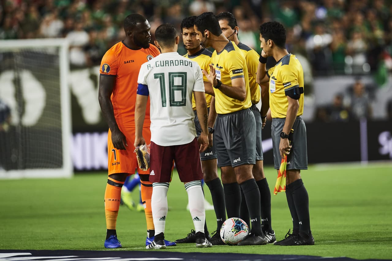 El saludo protocolario entre capitanes, Andrés Guardado (18) por México y Johnny Placide, guardameta de Haití.