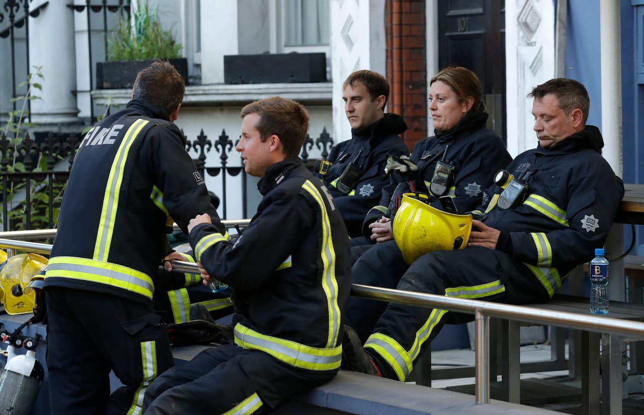 Después de seis horas de intenso trabajo contínuo contra las llamas y en labores de salvamento estos bomberos de Londres toman un espacio para descansar.