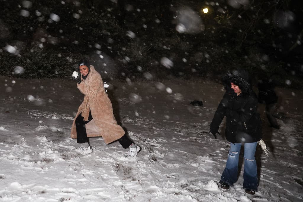 Dos personas juegan con la nieve en Central Park en la noche de este domingo 19 de enero de 2025.