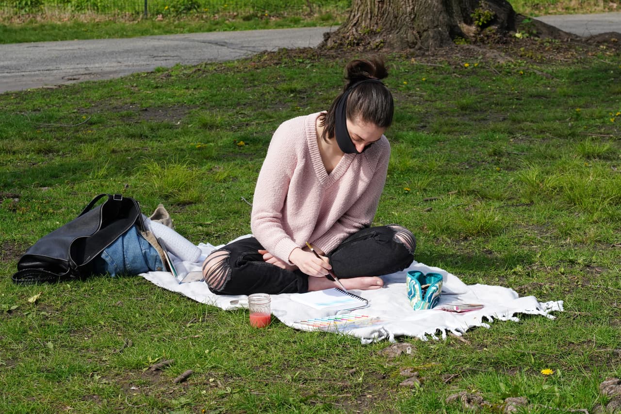 Una mujer pinta con una mascarilla negra en Central Park
