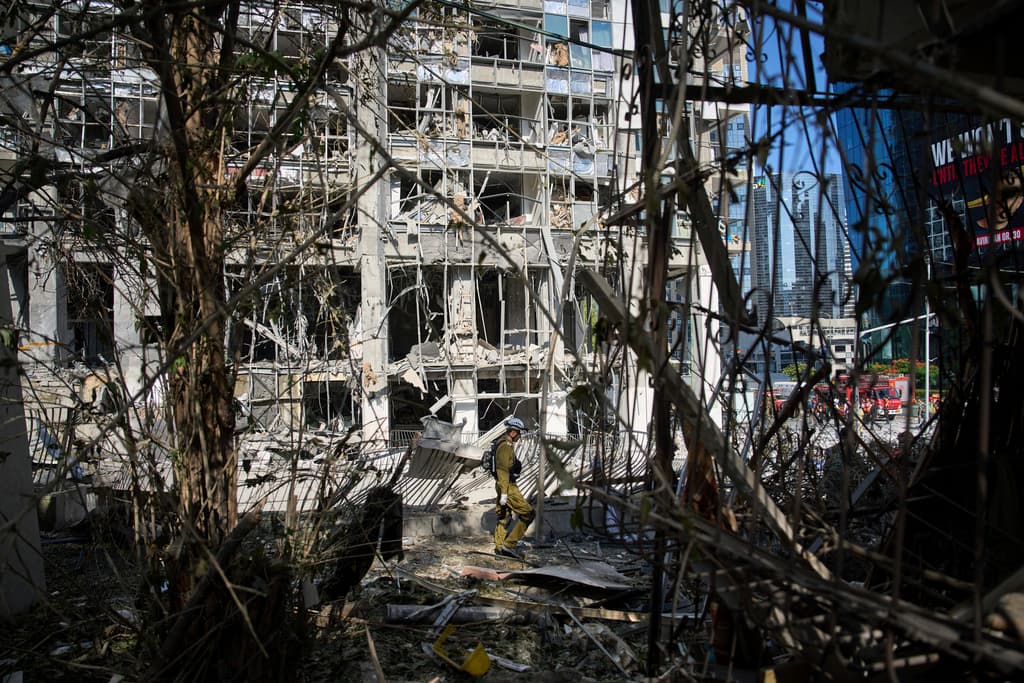 Equipos de rescate y personal militar inspeccionan el lugar del impacto directo de un misil iraní en Ramat Gan, Israel, este jueves 19 de junio de 2025.