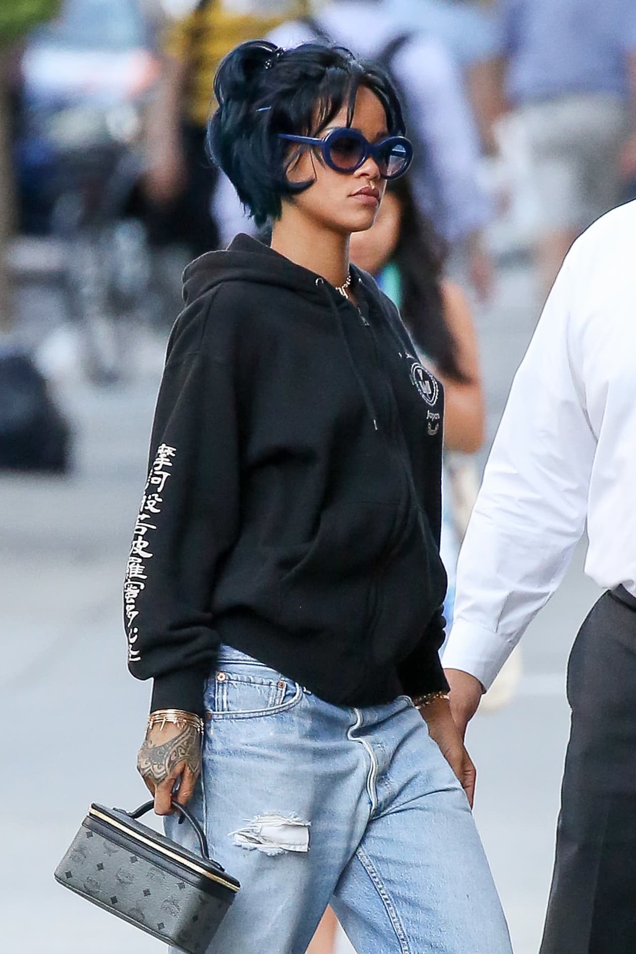 Rihanna con jeans demasiado grandes y nuevos 'rayitos' azules en su cabello.