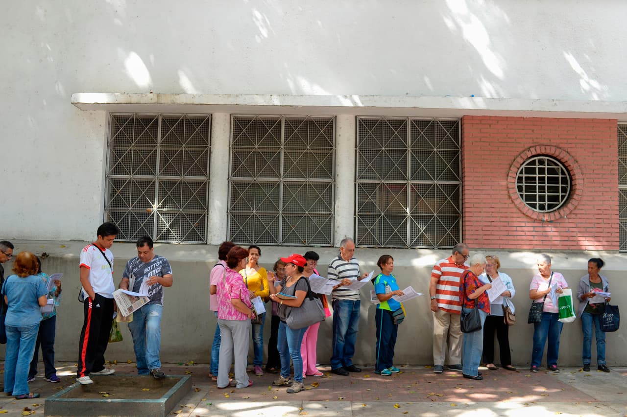 Partidarios del gobierno de Nicolás Maduro esperan su turno para votar en el simulacro de elección constituyente en Caracas. Los participantes deberán enviar un mensaje de texto indicando que ya estuvieron en el ejercicio de hoy y también llevar su "carnet de la patria", en un proceso totalmente controlado por el partido de gobierno, PSUV.
