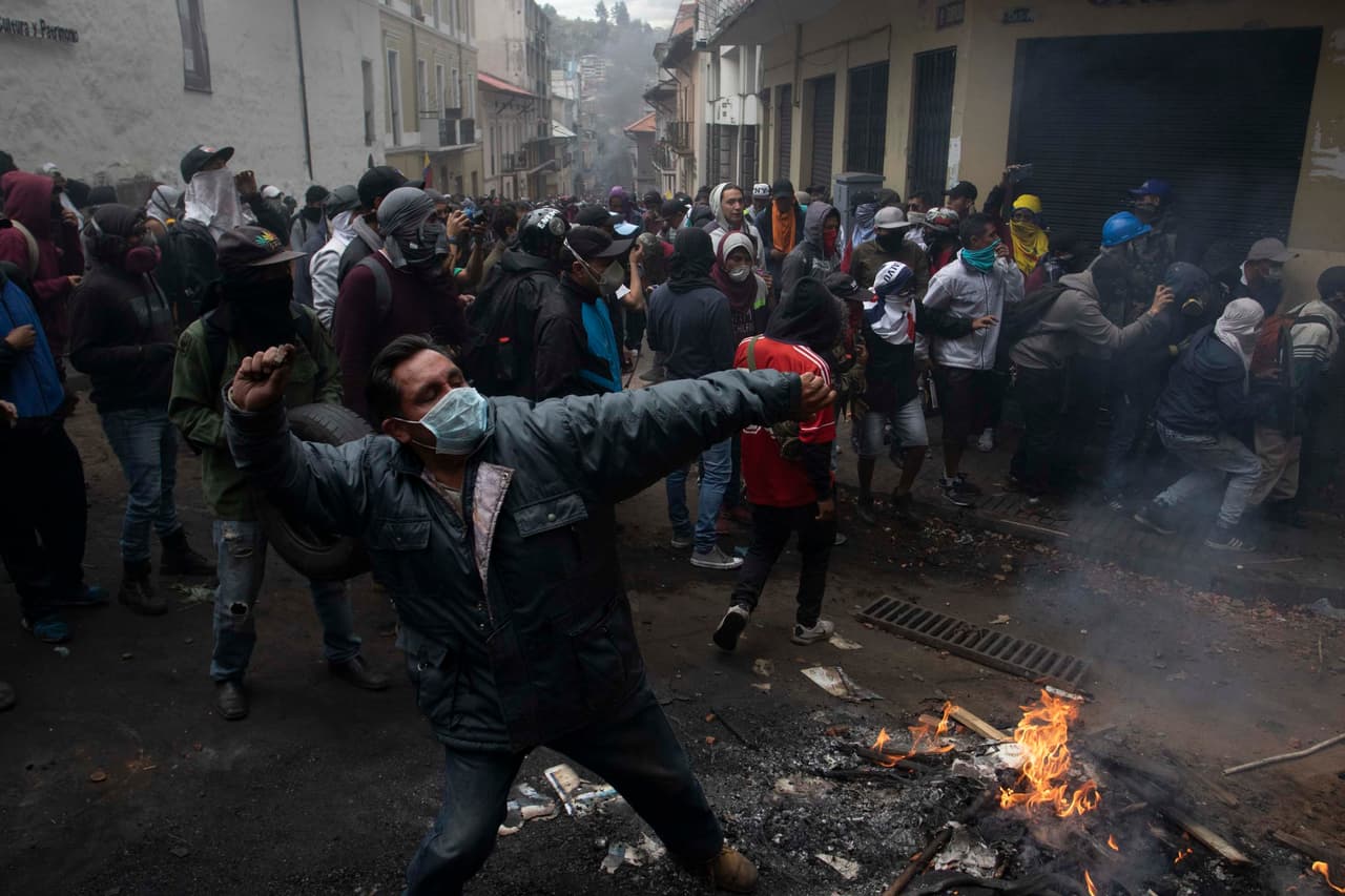 Un manifestante arroja piedras a la policía durante las protestas contra el fin de los subsidios a combustibles anunciados por el presidente Lenin Moreno. El gobierno calificó las manifestaciones como un intento de golpe de estado. Moreno dice que el ex-presidente Rafael Correa y el presidente de Venezuela, Nicolás Maduro, están detrás de ello.