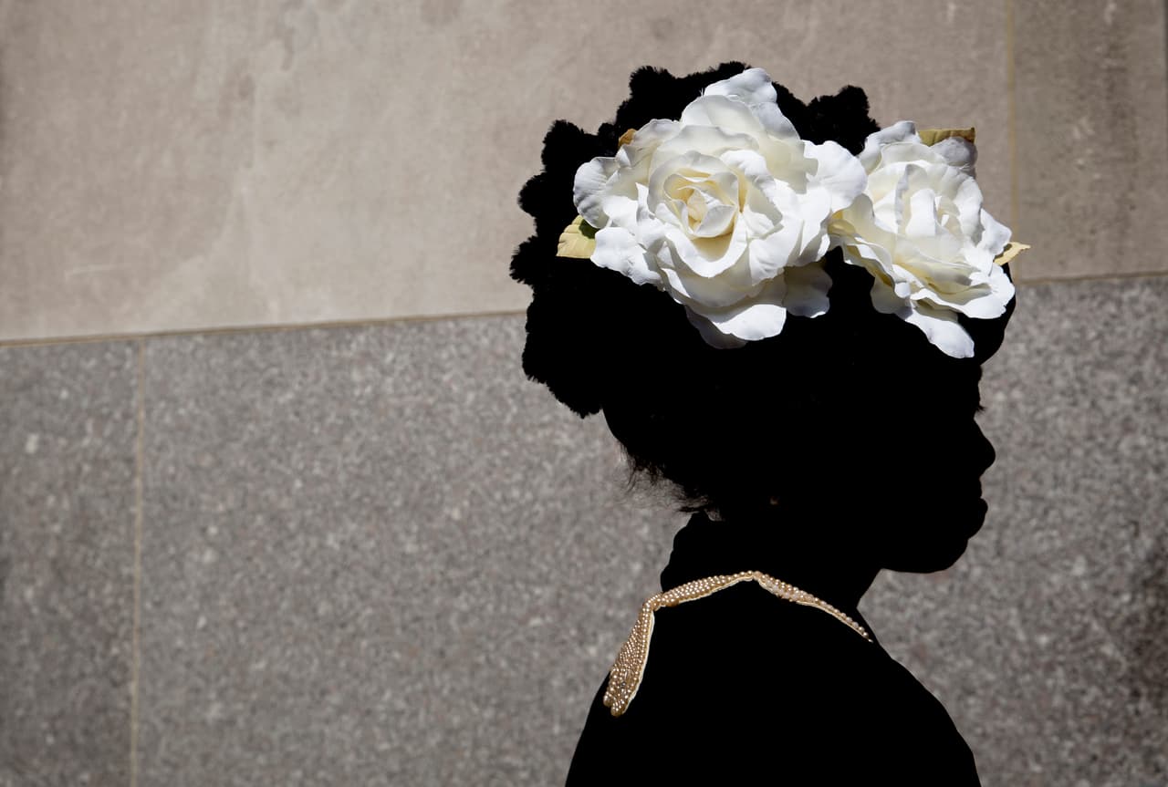 Lana Turner lleva dos enormes rosas blancas como sombrero durante el desfile