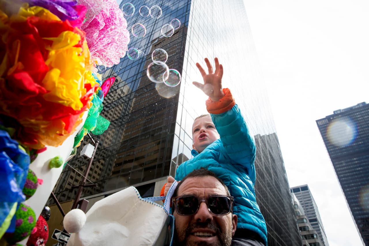 Un niño rompe burbujas de jabón durante el desfile de Pascua