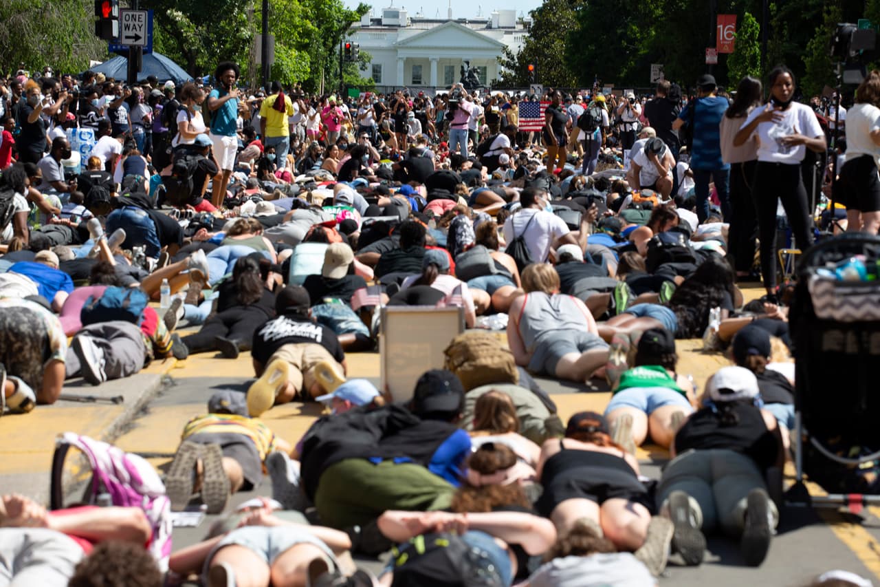Manifestantes se echan sobre el pavimento y frente a la Casa Blanca durante una protesta en la Plaza Lafayette. La policía dispersó con gas lacrimógeno la tarde del lunes 1 de junio a manifestantes que se encontraban en esa plaza poco antes de que el presidente Donald Trump caminara hasta una iglesia cercana que había sido dañada durante protestas que se habían tornado violentas la noche anterior.