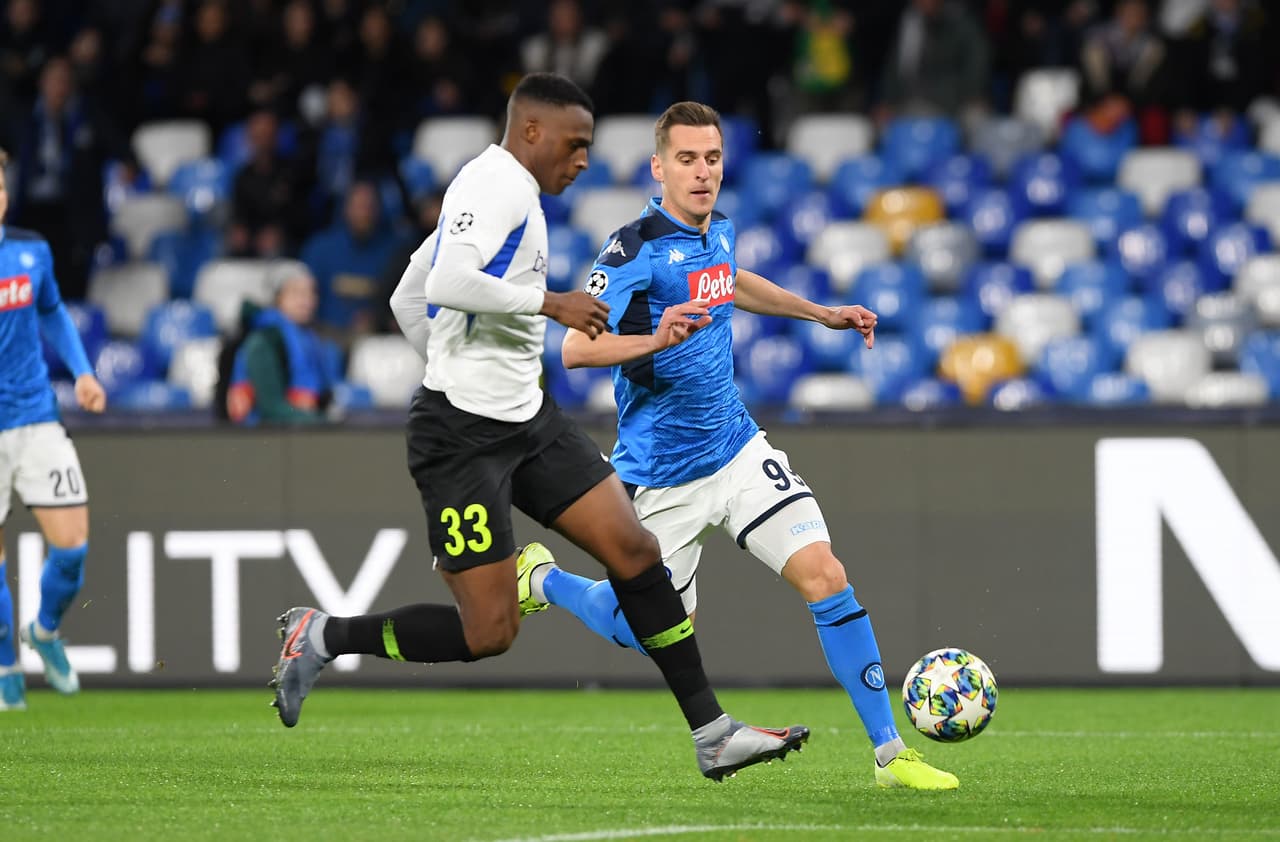 Arkadiusz Milik del SSC Napoli tras el balón junto con Jhon Lucumi del KRC Genk.