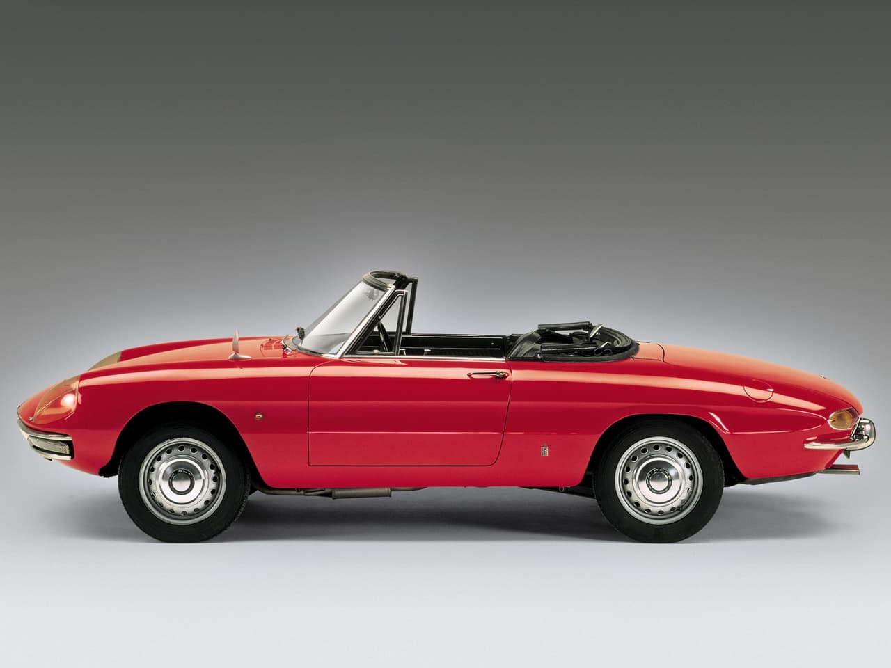 En 1966 aparecía el Alfa Romeo Spider. Un deportivo con 2 asientos, motor delantero y tracción posterior. Alfa Romeo construyó casi 150,000 unidades del ‘roadster’ durante sus casi 30 años de vida (1966 y 1994). En esta foto vemos el Alfa Romeo Spider 1600 de 1966.
