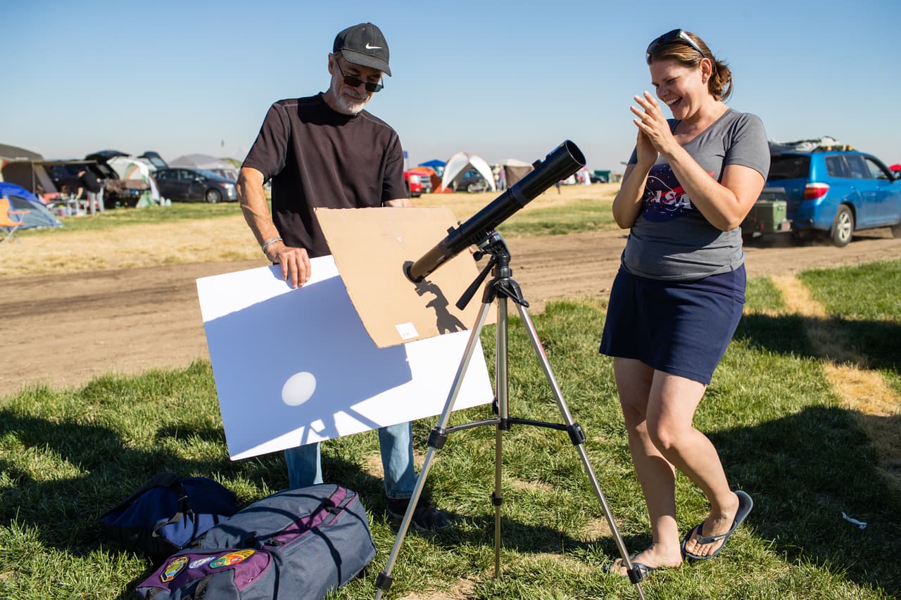 Mientras muchos de los viajeros que llegaron a Madras, Oregon esperan pacientes el festín que va a haber en el cielo mañana, John Adlington y Tricia Dacie se ocuparon hoy de acomodar un telescopio para ver de manera segura el momento en el que la luna tape por completo el sol.