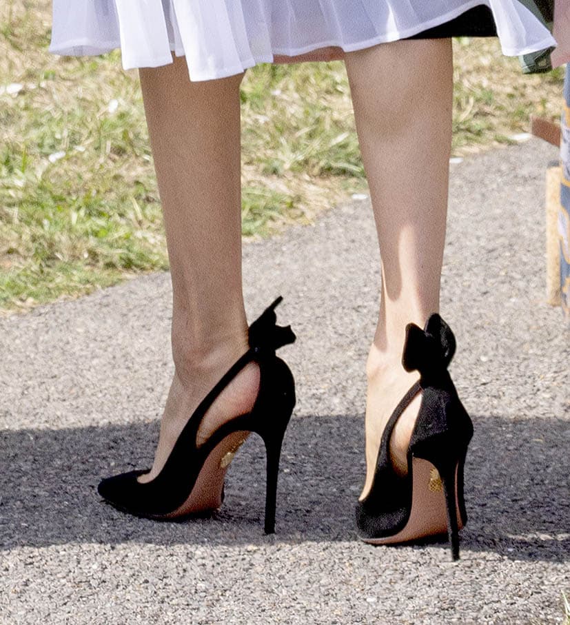 Markle usó sus clásicos tacones negros de la marca 
<b><a href="https://www.aquazzura.com/en/boutique-online/woman/view-all.html?gclid=CjwKCAjwhqXbBRAREiwAucoo-wuIo3Au1t52dRj1UVQrGlBFRmJPK4IWXb4JVdxegydbdOVql5LtBRoCCKIQAvD_BwE">Aquazzura</a></b> y tienen un valor de
<b><a href="https://shop.nordstrom.com/s/aquazzura-deneuve-bow-pointy-toe-pump-women/4948641?siteid=tv2R4u9rImY-e4xDuBv2XHZWv4Eo2buNwA&siteid=tv2R4u9rImY-EhJTozVS6IGpibsv3YmFrA&siteid=TnL5HPStwNw-Sb8jvdpTrutnm0MrlLNlaw&country=US&currency=USD&utm_content=9383573633_b33e1eb0-16f2-455e-adf5-f24c4a0c3c15&utm_term=aud-425188852237:pla-314712803026&utm_channel=shopping_ret_p&sp_source=google&sp_campaign=645528200&gclid=EAIaIQobChMIj9jpru683AIVxZCfCh3DfwQ-EAQYASABEgKAo_D_BwE" target="_blank"> 750 dólares</a></b>. El bolso clutch con el que acompañó todo el vestuario es de la firma 
<a href="https://kayudesign.com/">Kayu</a>.