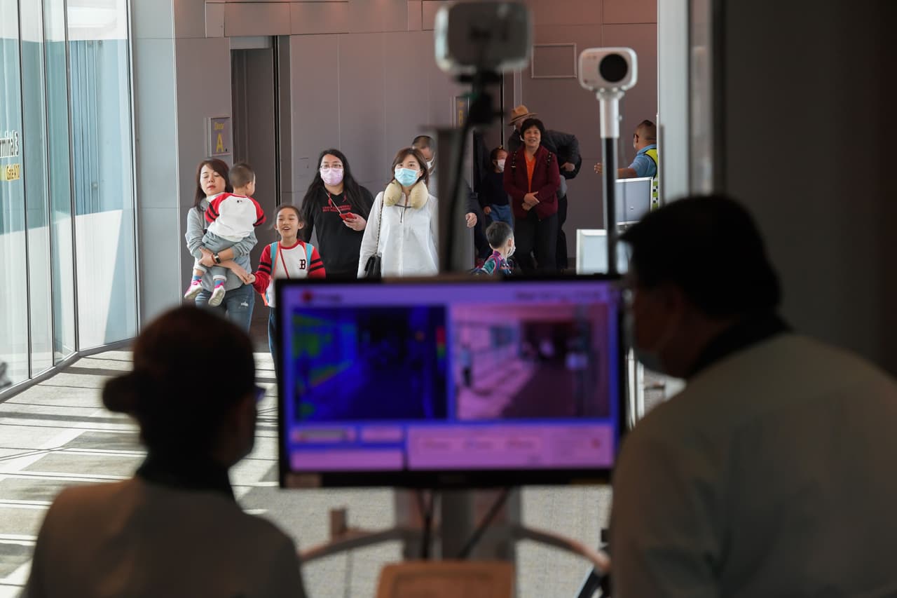 Los casos comenzaron a ser reportados durante el inicio de la agitada temporada de viajes por la festividad del Año Nuevo Lunar. Muchos chinos viajan al extranjero para la ocasión y se han confirmado fuera de China, incluidos Corea del Sur, Japón, Tailandia, Taiwán y Estados Unidos. La fotografía muestra a los oficiales de salud que examinan a los pasajeros que llegan de China al aeropuerto internacional de Singapur, el 22 de enero de 2020.