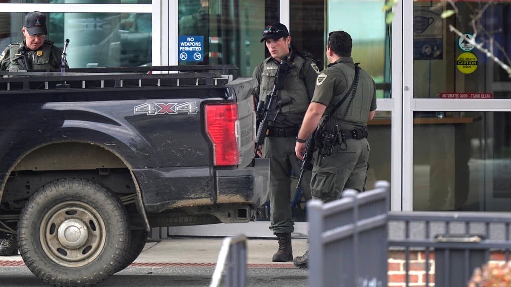 Agentes del orden armados con rifles son vistos en la entrada del servicio de emergencias del Central Maine Medical Center durante en Lewiston, Maine, el jueves 26 de octubre de 2023. Los tiroteos masivos en un restaurante y una bolera en esa ciudad, el miércoles por la noche, provocaron una búsqueda masiva del sospechoso que aún continúa.