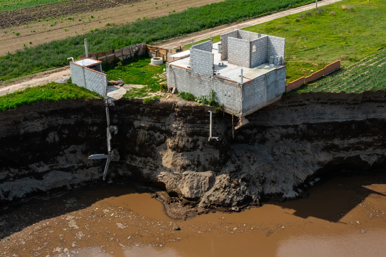 Esta imagen muestra a una construcción amenazada por el crecimiento
<a href="https://www.excelsior.com.mx/nacional/inicia-rescate-de-perros-atrapados-en-socavon-de-puebla/1454030" target="_blank">del socavón</a> que, según las autoridades, fue provocado por "flujos de agua subtérranea", lo que rechazan otras fuentes, que aseguran que se debió a la extracción excesiva.
