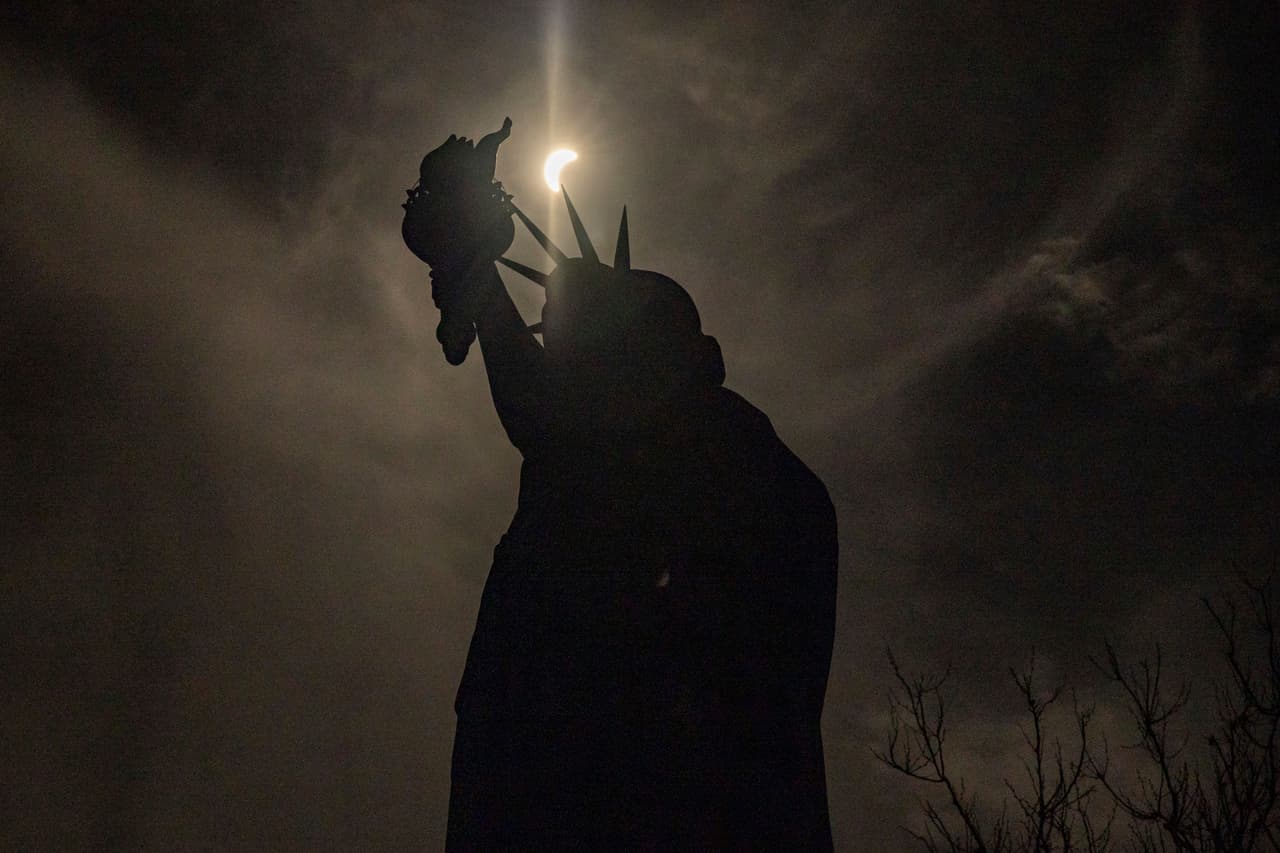 La estatua de la Libertad fue uno de los sitios a los que acudieron paseantes y turistas a observar el eclipse.