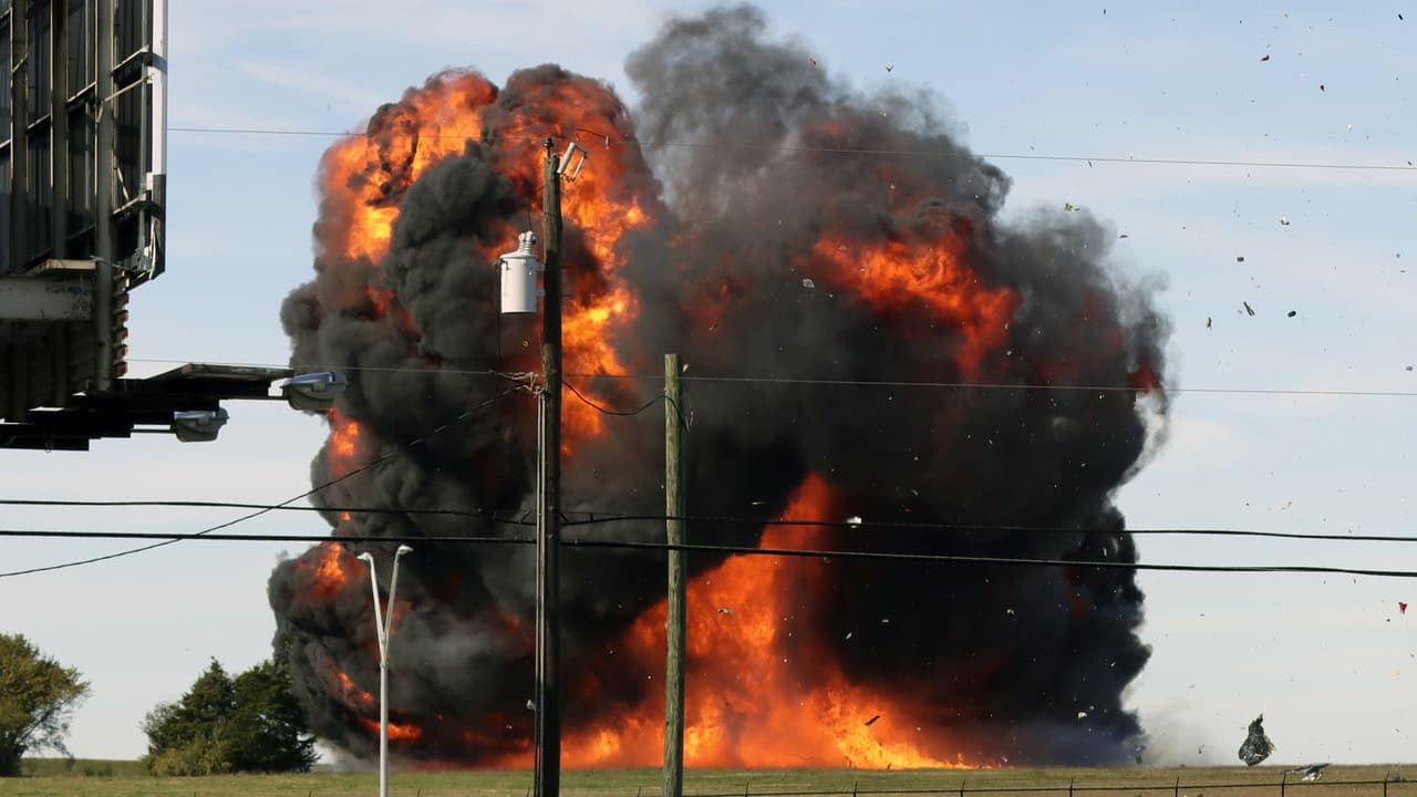 En esta imagen proporcionada por Nathaniel Ross Photography, un histórico avión militar se impacta contra el suelo tras chocar en pleno vuelo con otro durante un espectáculo aéreo en el Aeropuerto Executivo de Dallas, el sábado 12 de noviembre de 2022.