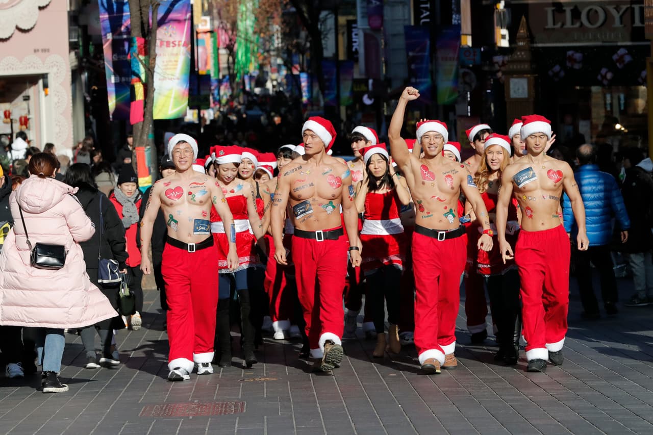 Hombres vestidos de Santa Claus marchan en una fría calle de Seul, Corea. Parte de una campaña para la donación órganos en ese país. 20 de diciembre de 2019.
