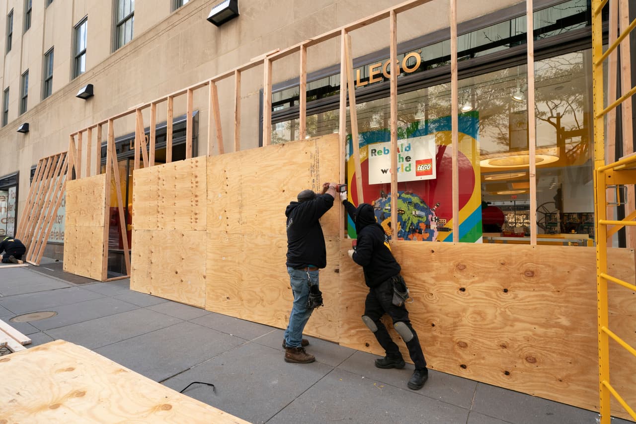 Empleados protegen las ventanas de una tienda en el Centro Rockefeller de Nueva York, el lunes 2 de noviembre. La zona cercana a la Torre Trump de Manhattan ha sido protagonista de numerosas protestas por el tema racial y algunas se tornaron violentas.
<br>