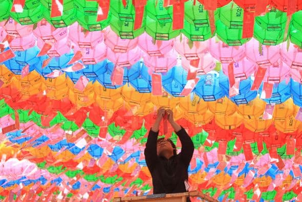 Un budista surcoreano cuelga linternas de colores para celebrar el próximo cumpleaños de Buda en el templo Chogye.