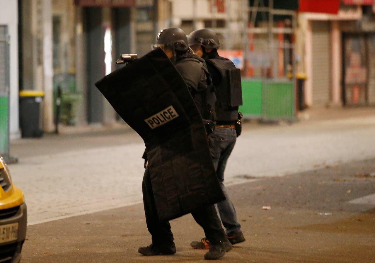 Dos policías caminan con un escudo de protección