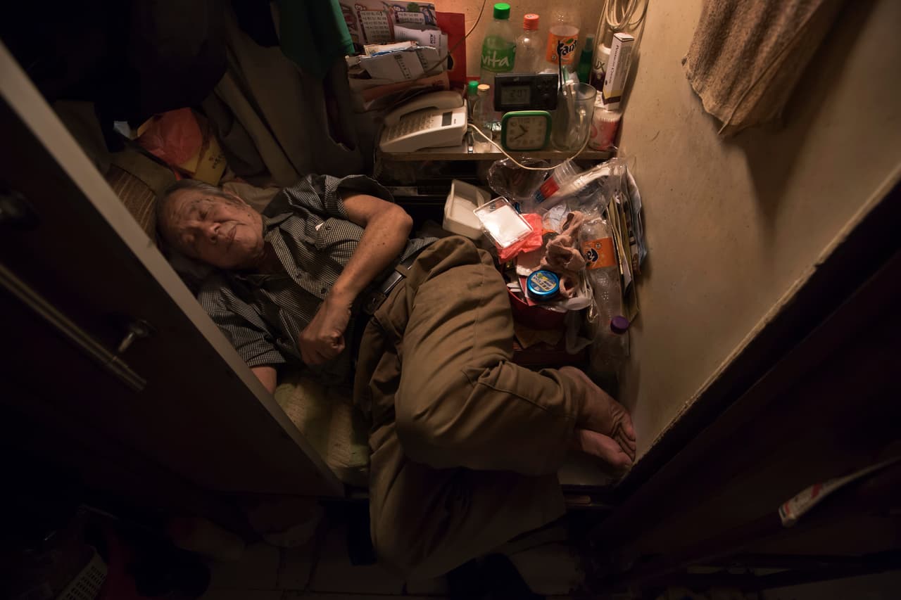 Cheung Chi-fong, de 80 años, duerme en su pequeña ‘casa ataúd’ donde no tiene espacio para estirar sus piernas.