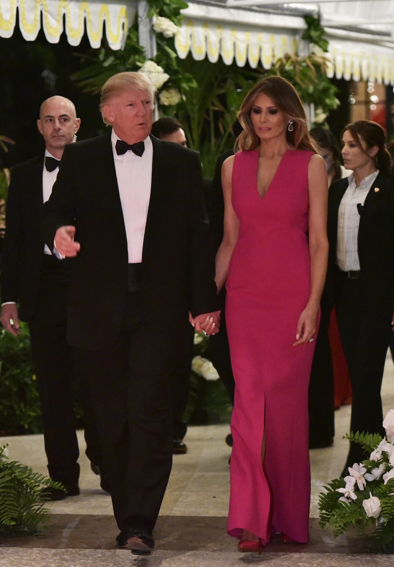Aunque en los eventos más relevantes en términos políticos Melania ha elegido a Ralph Lauren y Michael Kors como sus aliados, en los momentos de gala no ha perdido oportunidad de mostrarle a la ciudadanía su opulento clóset. Para la gala de la Cruz Roja ofrecida en Palm Beach, Florida,
<b>llevó este vestido fucsia de abertura central de la casa francesa Christian Dior.</b>