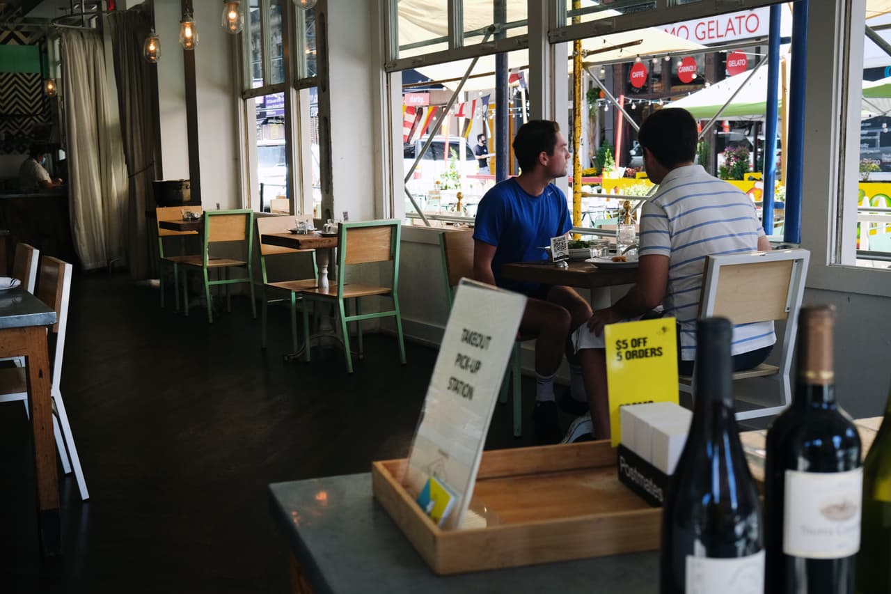 La gente cena dentro de un restaurante en la Pequeña Italia
