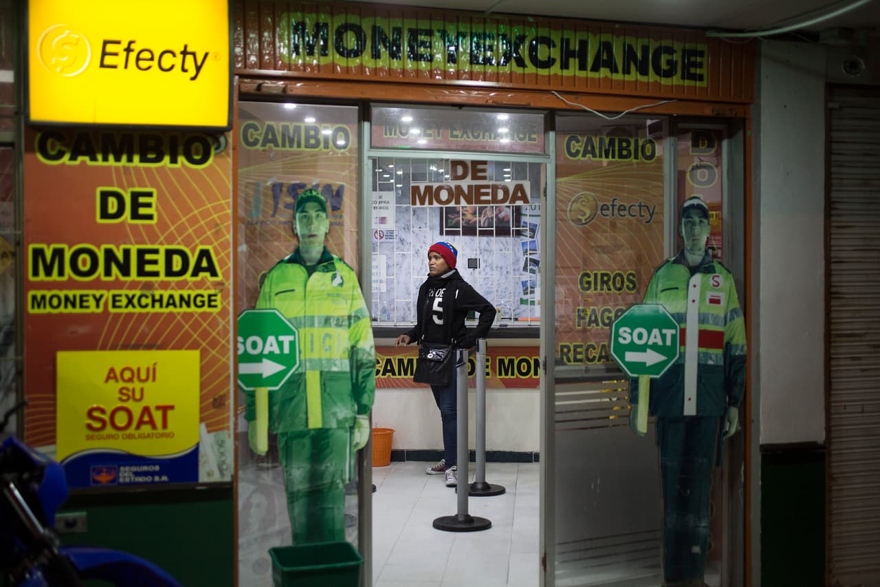 Una mujer cambia dinero en el puente de Rumichaca. Al cambiar sus bolívares, muchos venezolanos se encuentran que todo su patrimonio no vale más de 10 dólares al cambio y ven la necesidad de pedir para seguir su viaje.