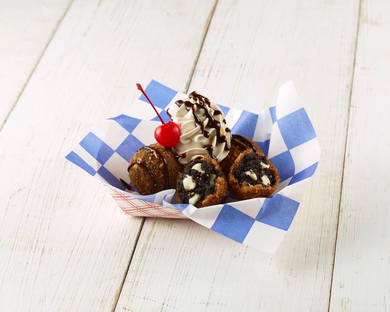QUICK FRIED “BLACK GOLD” TRUFFLES - Una delicia hecha de delgadas galletas de chocolate trituradas en migajas combinadas con queso crema. Se le agregan mini chips de chocolate blanco enrollados a mano en bolas y recubiertos con un pan dorado. También lleva hojuelas de maíz, canela y nuez moscada fritas para obtener un crujido en el exterior y una dulzura cremosa en el interior.