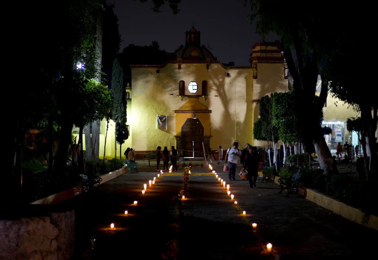 Un sendero hecho de velas y flores conduce a la iglesia principal en San Gregorio Atlapulco, Xochimilco, donde el altar del Día de los Muertos rinde homenaje a dos personas que murieron cuando la cúpula de la iglesia cayó durante el terremoto.