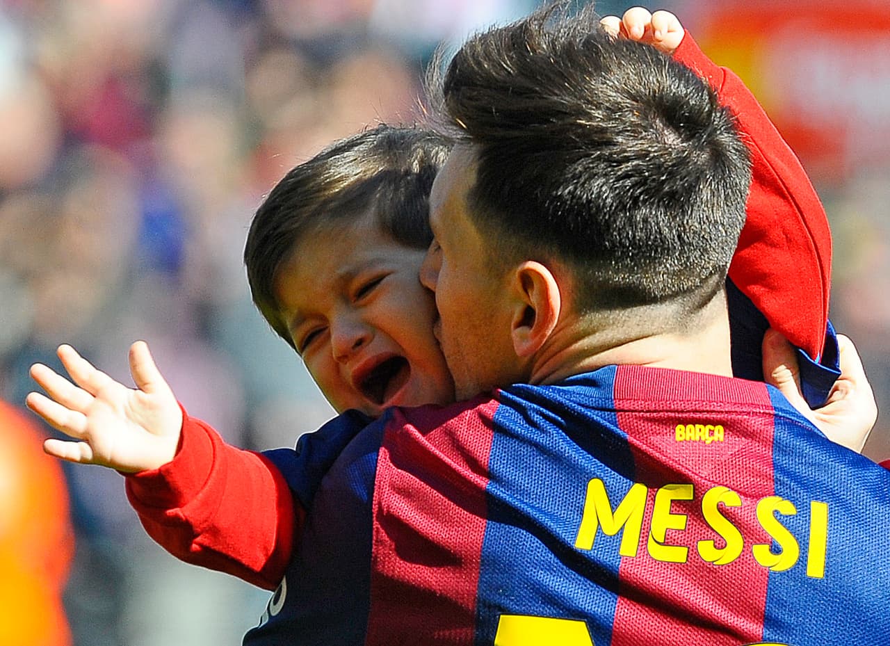 Thiago no muy feliz de recibir un besito de papá.