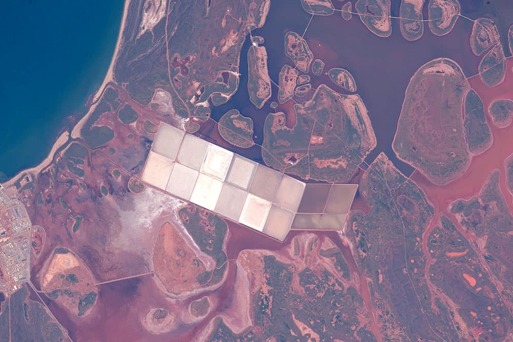 Aquí las lagunas costeras con numerosas islas redondeadas son típicas de la costa del Océano Índico en el oeste de Australia. Estas formas contrastan con los estanques blancos angulares de la industria de extracción de sal. Esta costa de Australia se caracteriza por su clima tropical y lejanía.