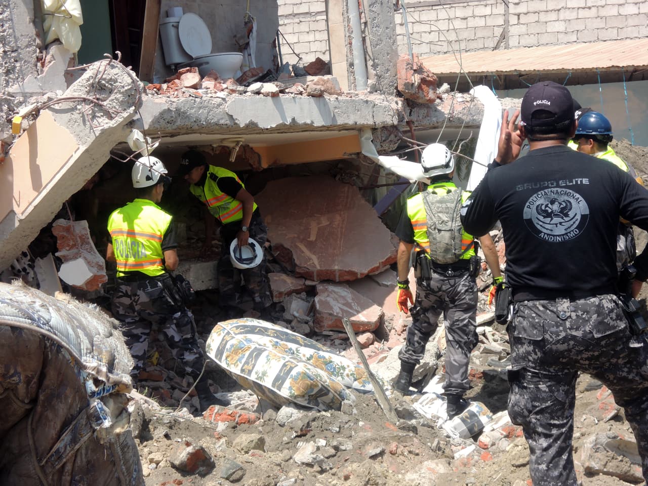 Los rescatistas buscan entre los escombros de lo que antes era un hotel en Canoa, una de las zonas más devastadas por el sismo de magnitud 7.8.