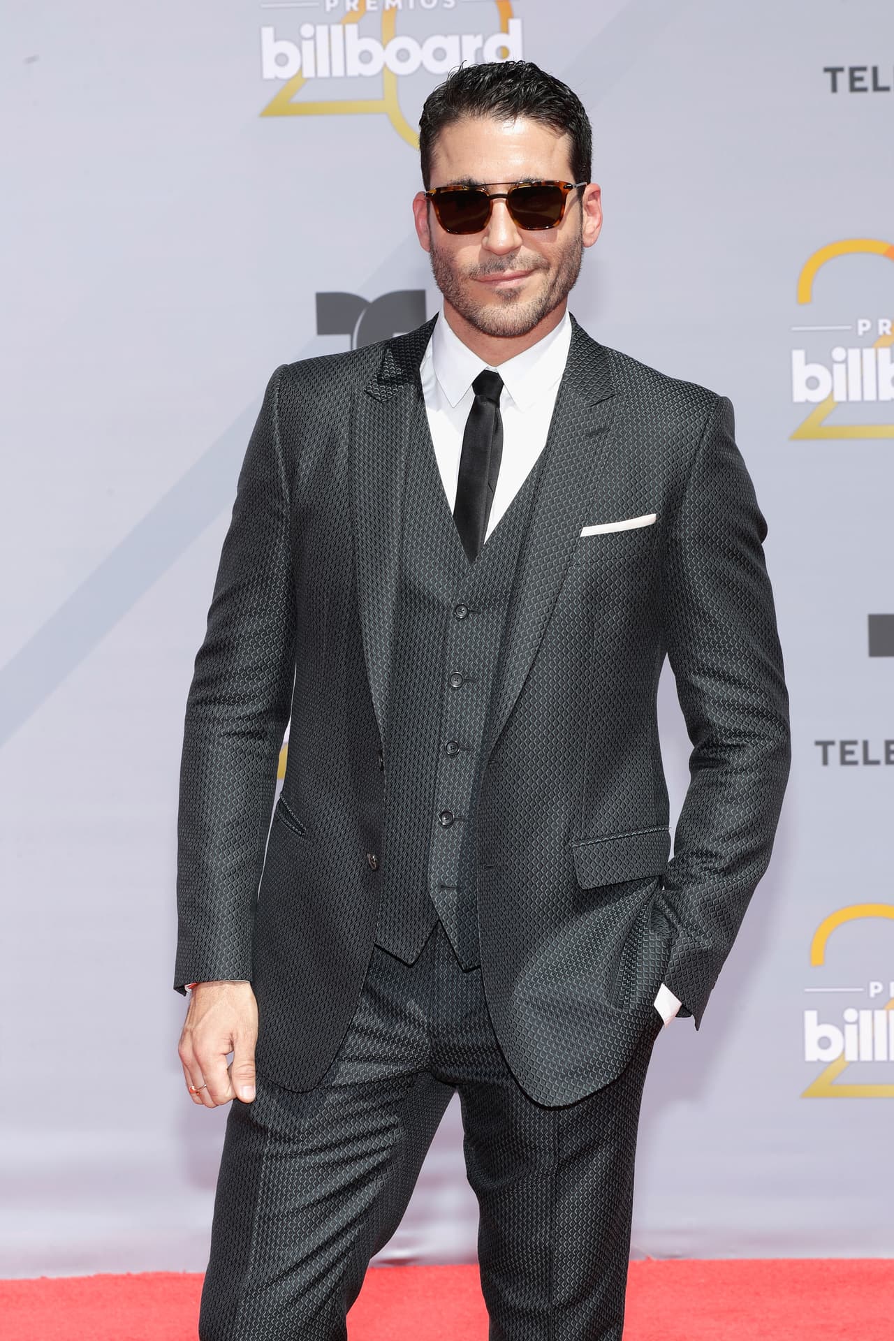 El español Miguel Ángel Silvestre lució un elegante smocking negro con una camisa blanca, corbata negra y completó su ‘look’ con unas gafas oscuras para combatir el sol de Las Vegas, Nevada.