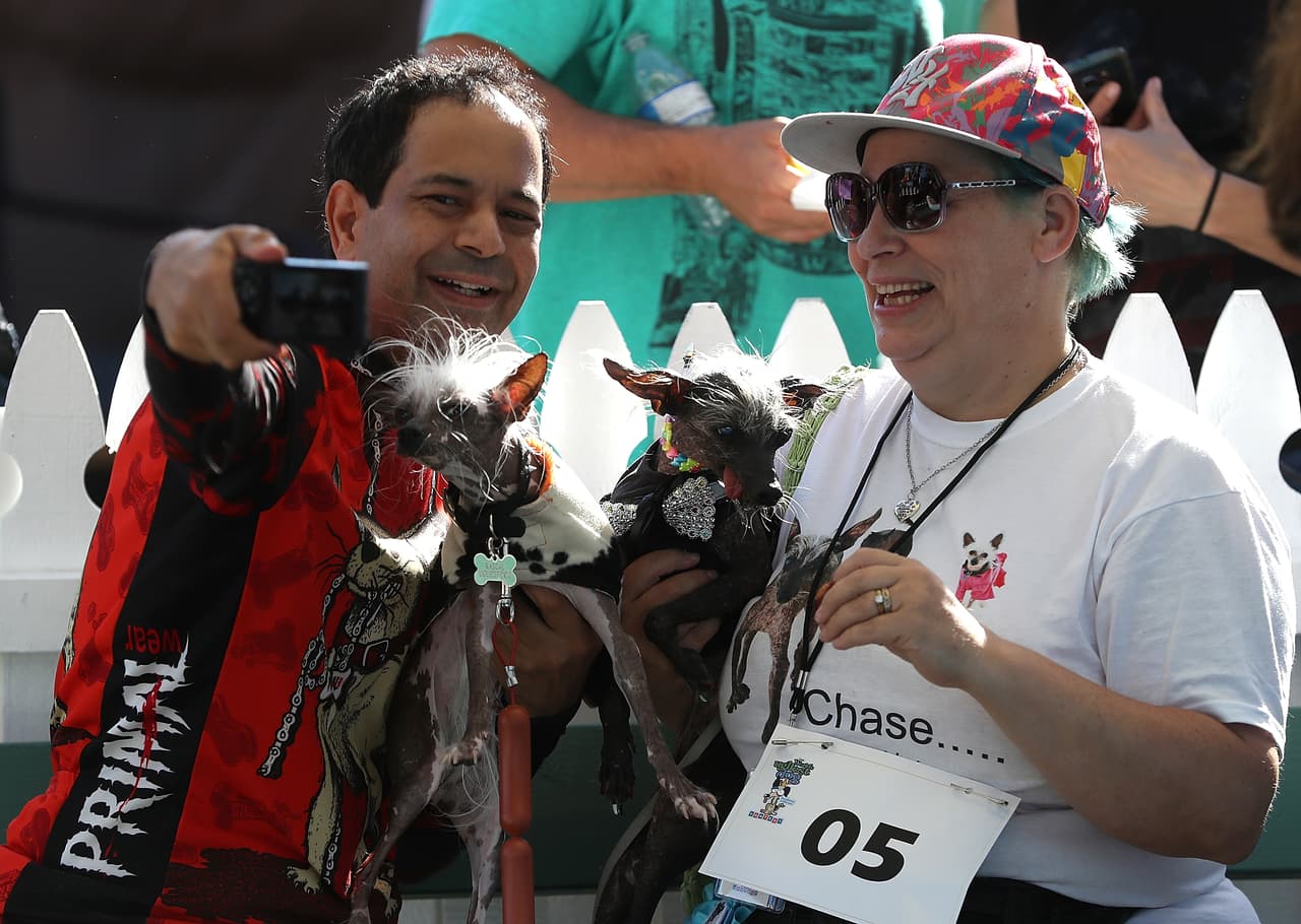 Dane Andrew (izquierda) de Sunnyvale, California, y Storm Shayler (derecha) de Neath, Reino Unido, se toman una fotografía con sus perros antes de que comenzara la competición en Sonoma-Marin Fair en California.